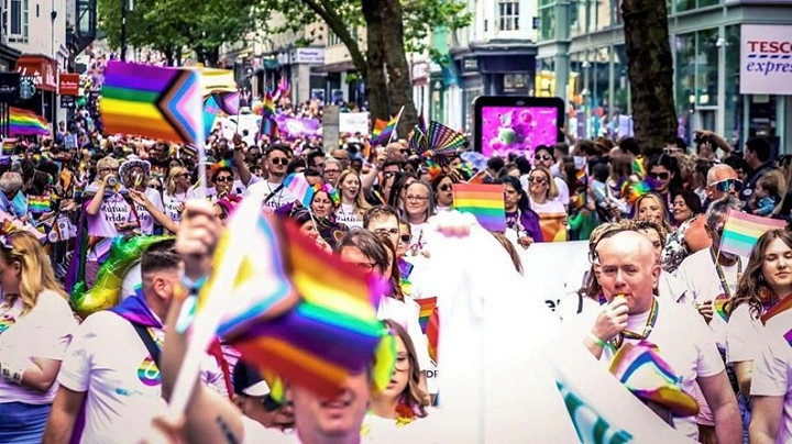 Large numbers of people walking in a pride parade in Birmingham